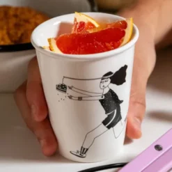 Porzellanbecher weiß - Motiv Frau jagt Kuchen